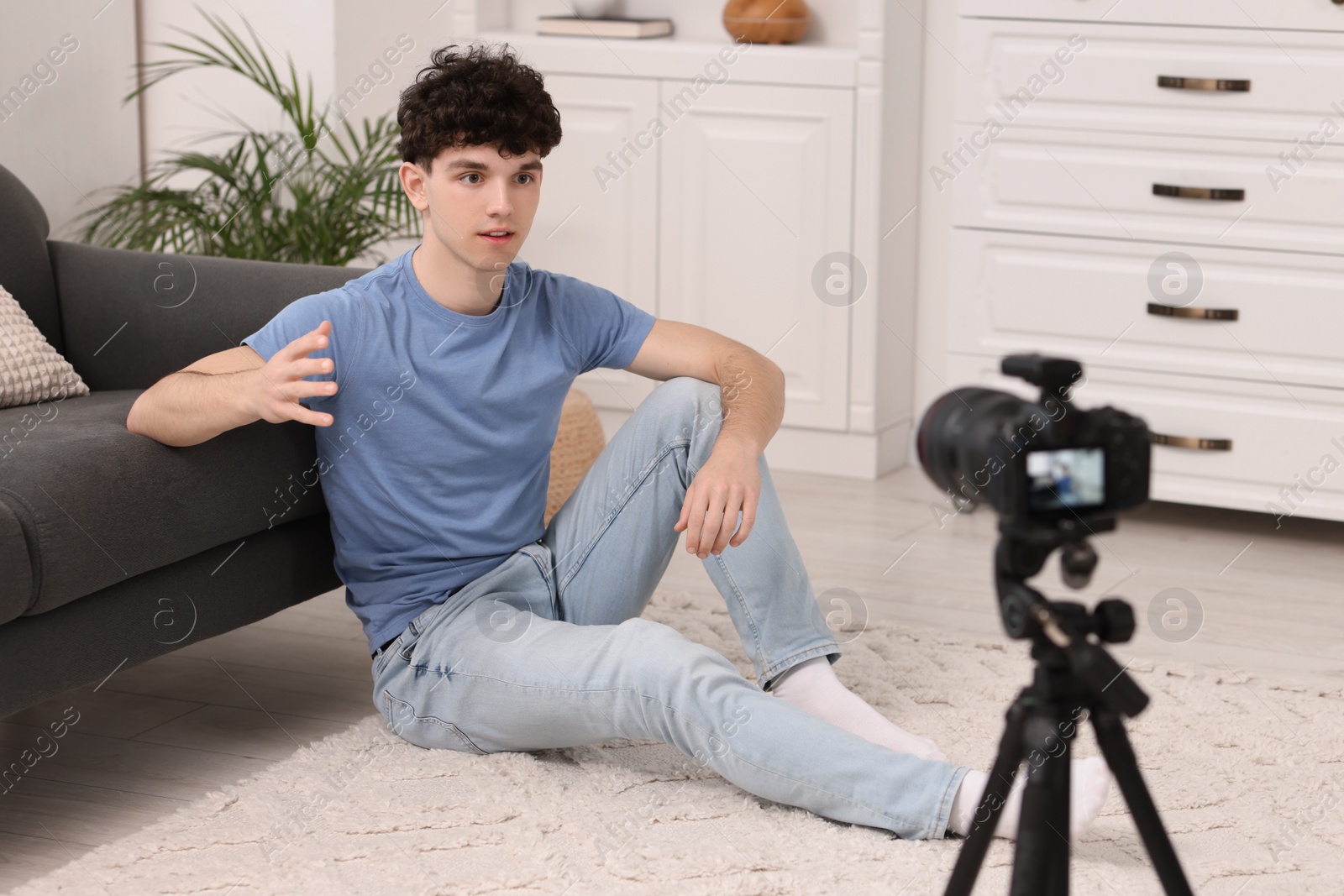 Photo of Teenage blogger explaining something while streaming at home