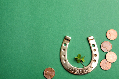 Flat lay composition with horseshoe on green background, space for text. St. Patrick's Day celebration