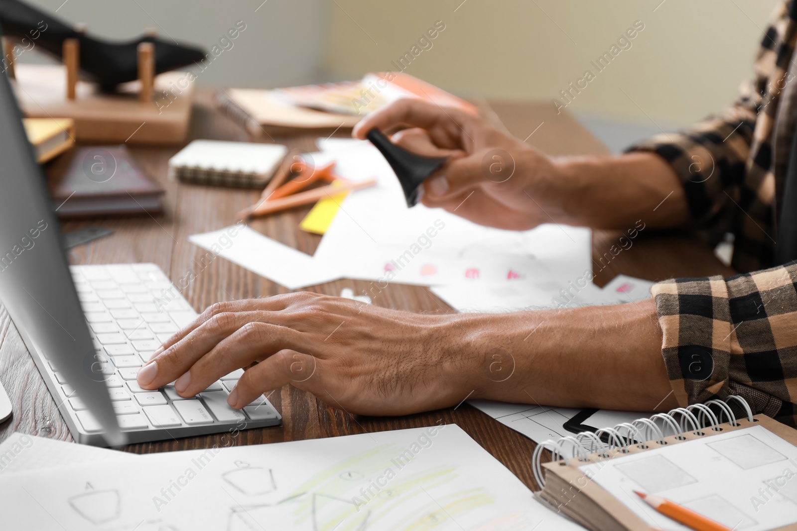 Photo of Male designer working at wooden table, closeup