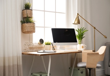 Photo of Light work place with computer near window at home. Interior design