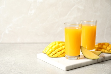 Photo of Fresh mango drink and cut fruits on table. Space for text