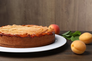 Photo of Tasty apricot pie on wooden table, closeup