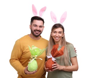Easter celebration. Happy couple with bunny ears and wrapped eggs isolated on white