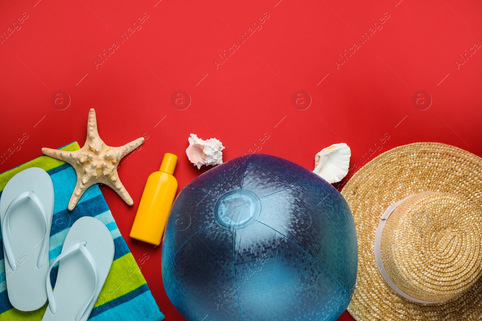 Photo of Flat lay composition with ball and beach objects on red background, space for text