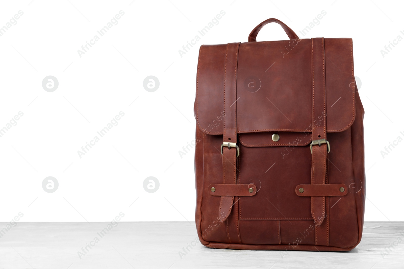 Photo of Stylish leather backpack on wooden table against white background. Space for text