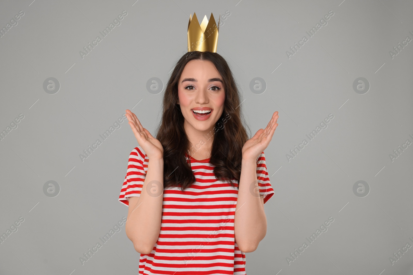 Photo of Beautiful young woman with princess crown on grey background