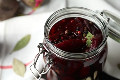 Pickled beets in glass preserving jar on table, closeup