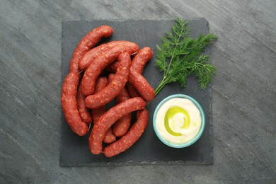 Tasty sausages, sauce and dill on black table, top view. Meat product