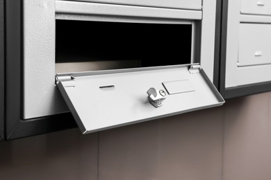 Photo of Open empty metal mailbox with keyhole indoors