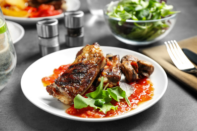 Photo of Delicious grilled ribs served on grey table