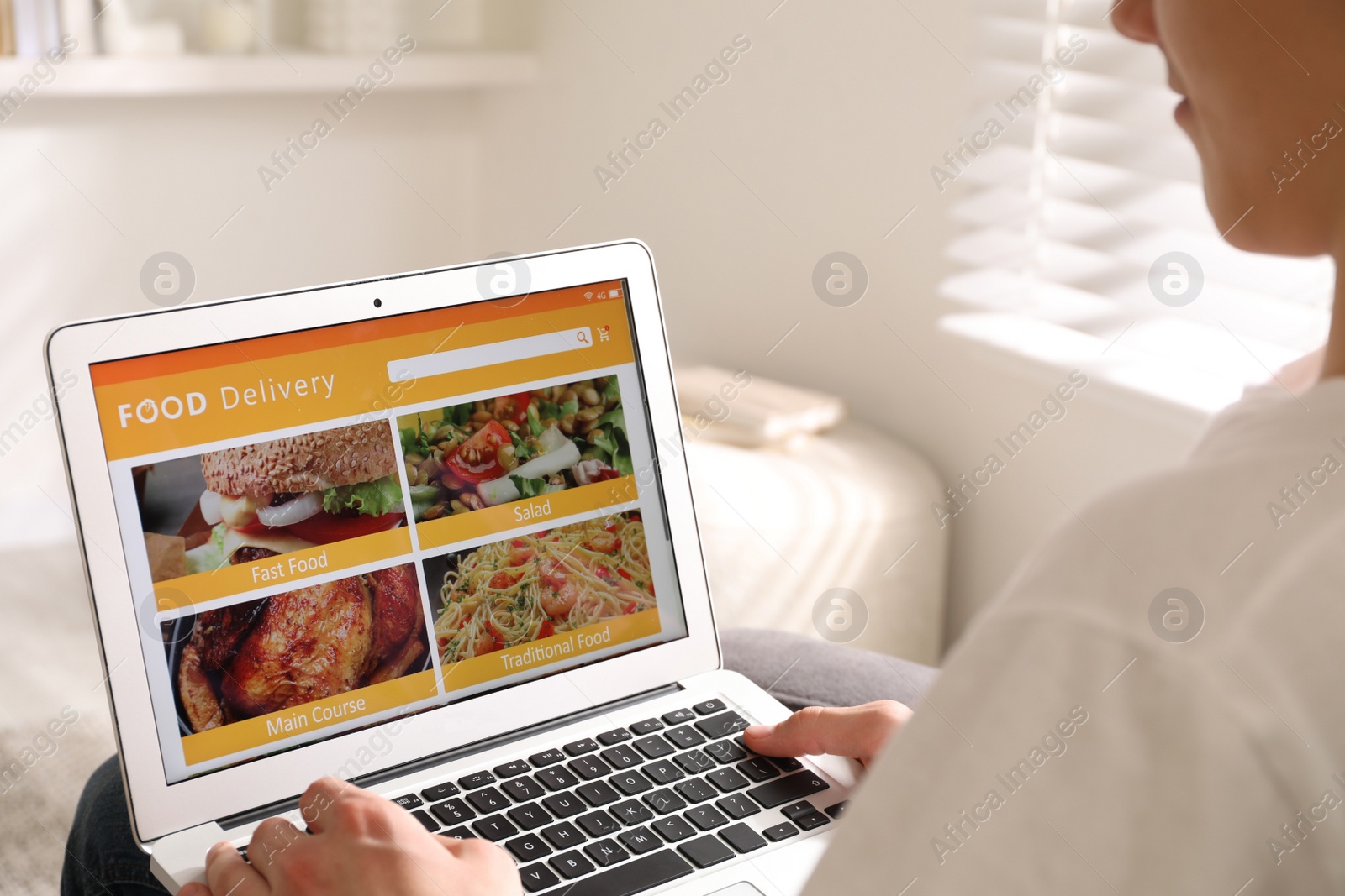 Photo of Man using laptop for ordering food online at home, closeup. Delivery service