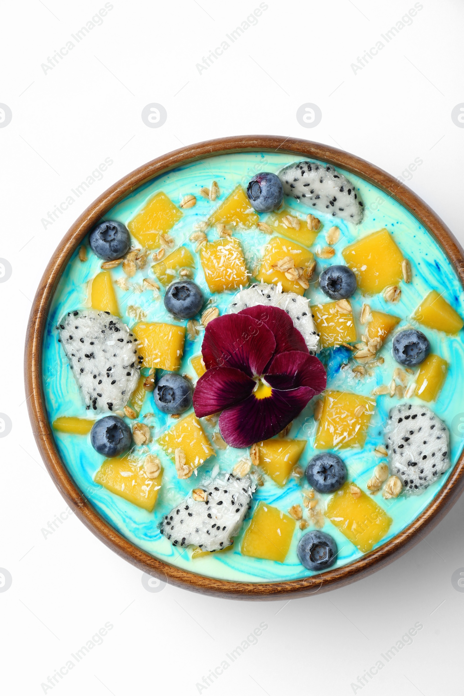 Photo of Delicious smoothie bowl with fresh fruits, blueberries, flower and oatmeal on white background, top view