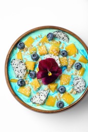 Photo of Delicious smoothie bowl with fresh fruits, blueberries, flower and oatmeal on white background, top view