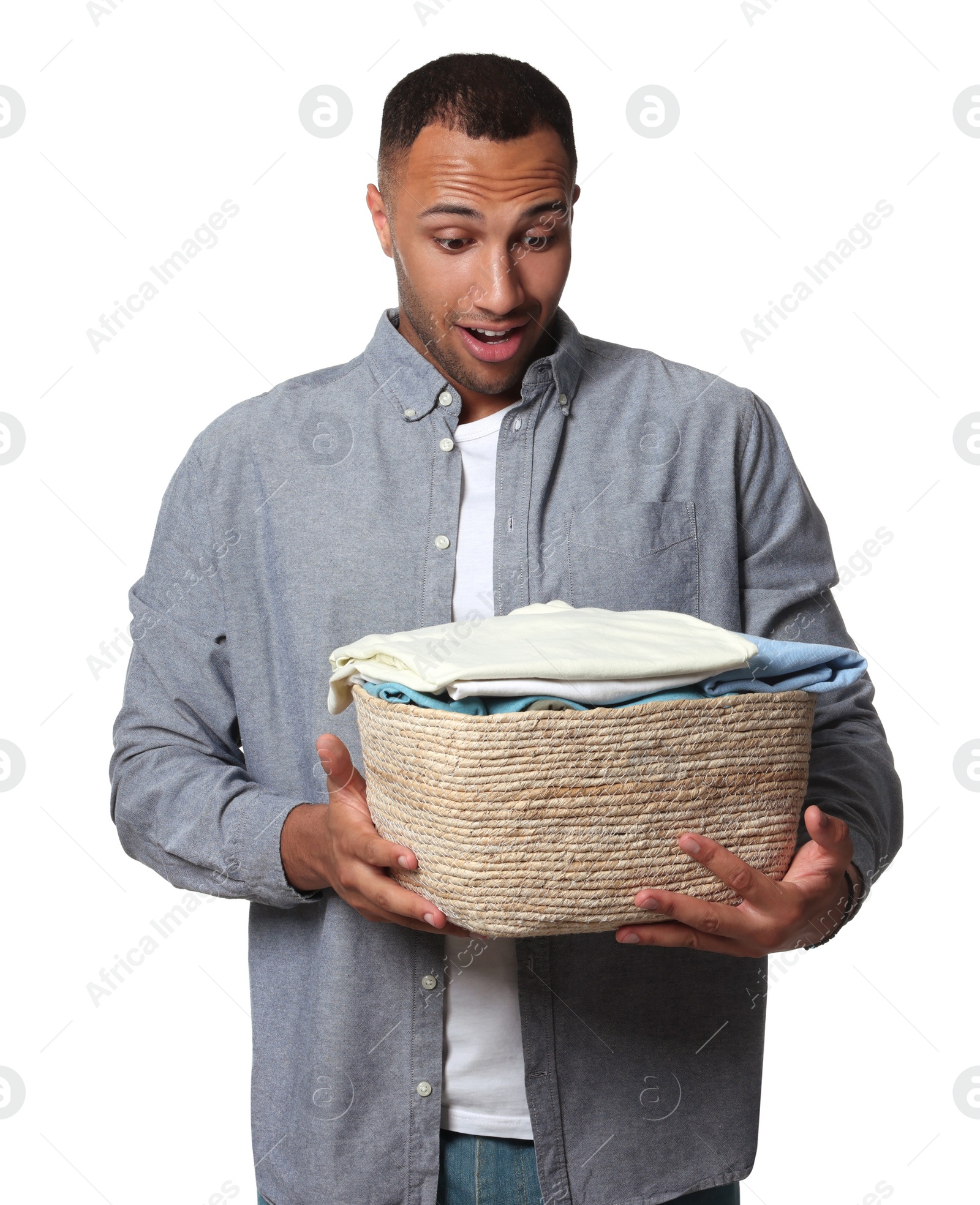 Photo of Emotional man with basket full of laundry on white background
