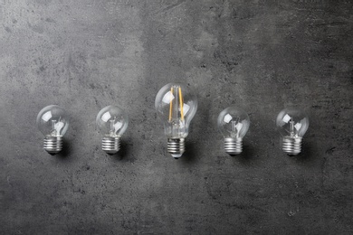 Photo of Vintage and modern lamp bulbs on grey stone surface, top view