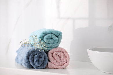 Photo of Rolled fresh towels on countertop in bathroom