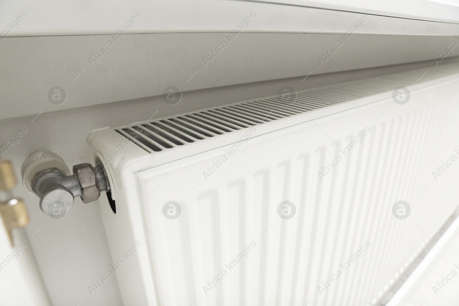 Photo of Closeup view of modern radiator. Central heating system