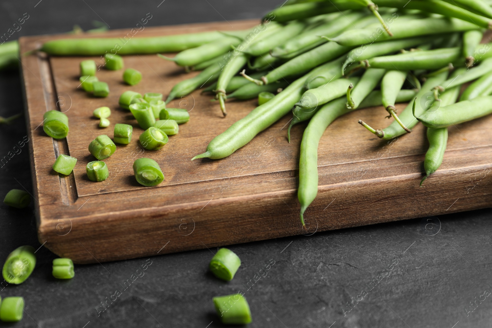 Photo of Fresh green beans on black table, closeup