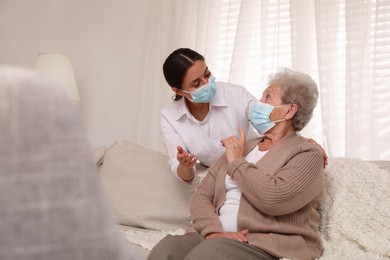 Doctor taking care of senior woman with protective mask at nursing home