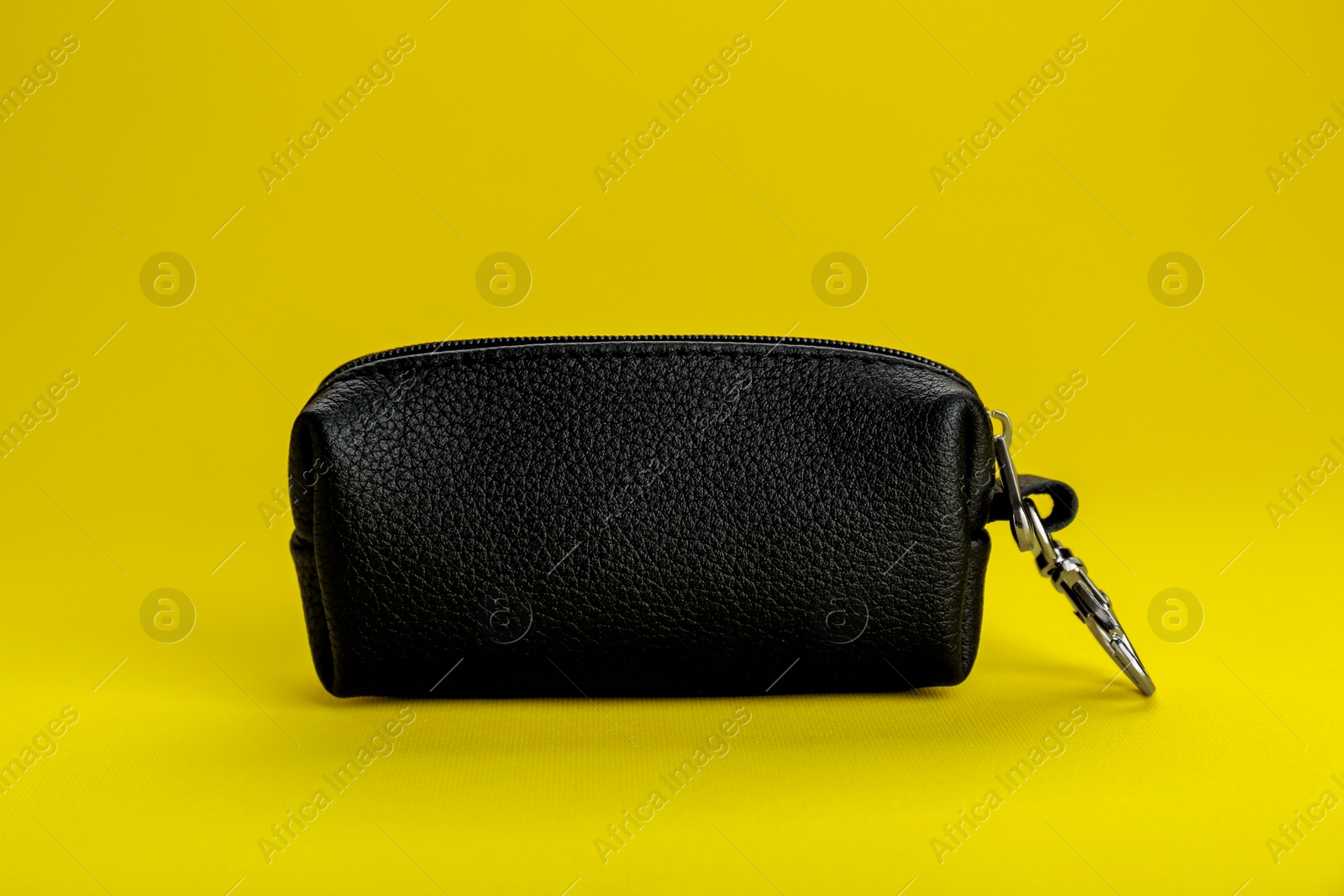 Photo of Stylish leather keys holder on yellow background