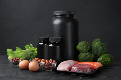 Photo of Set of products rich in amino acids and supplements on black table
