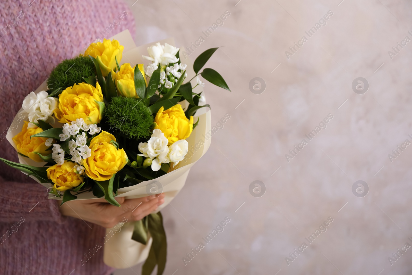 Photo of Woman with bouquet of beautiful tulips on beige background. Space for text