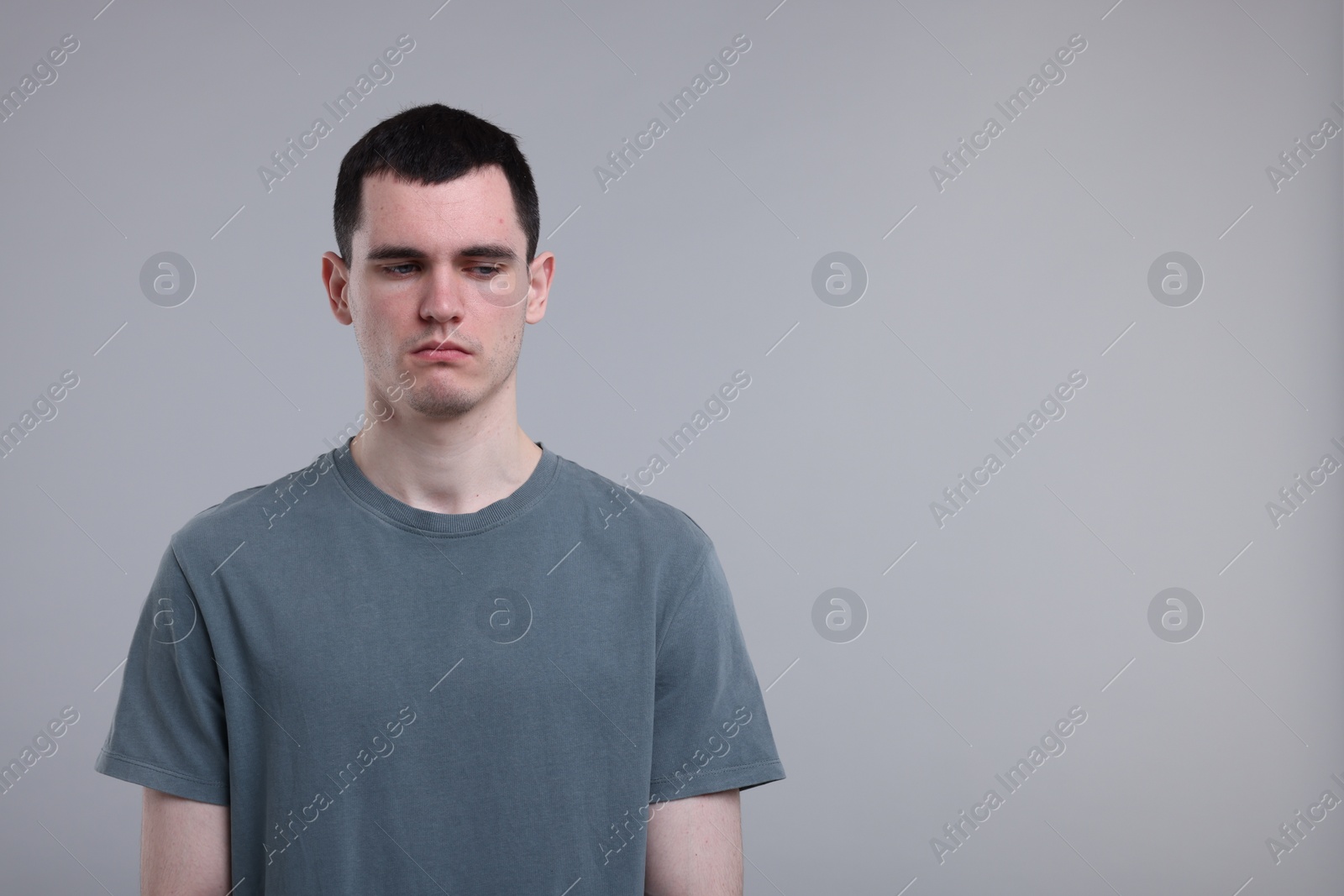 Photo of Portrait of sad man on grey background, space for text