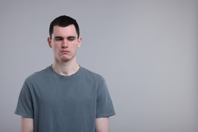 Photo of Portrait of sad man on grey background, space for text