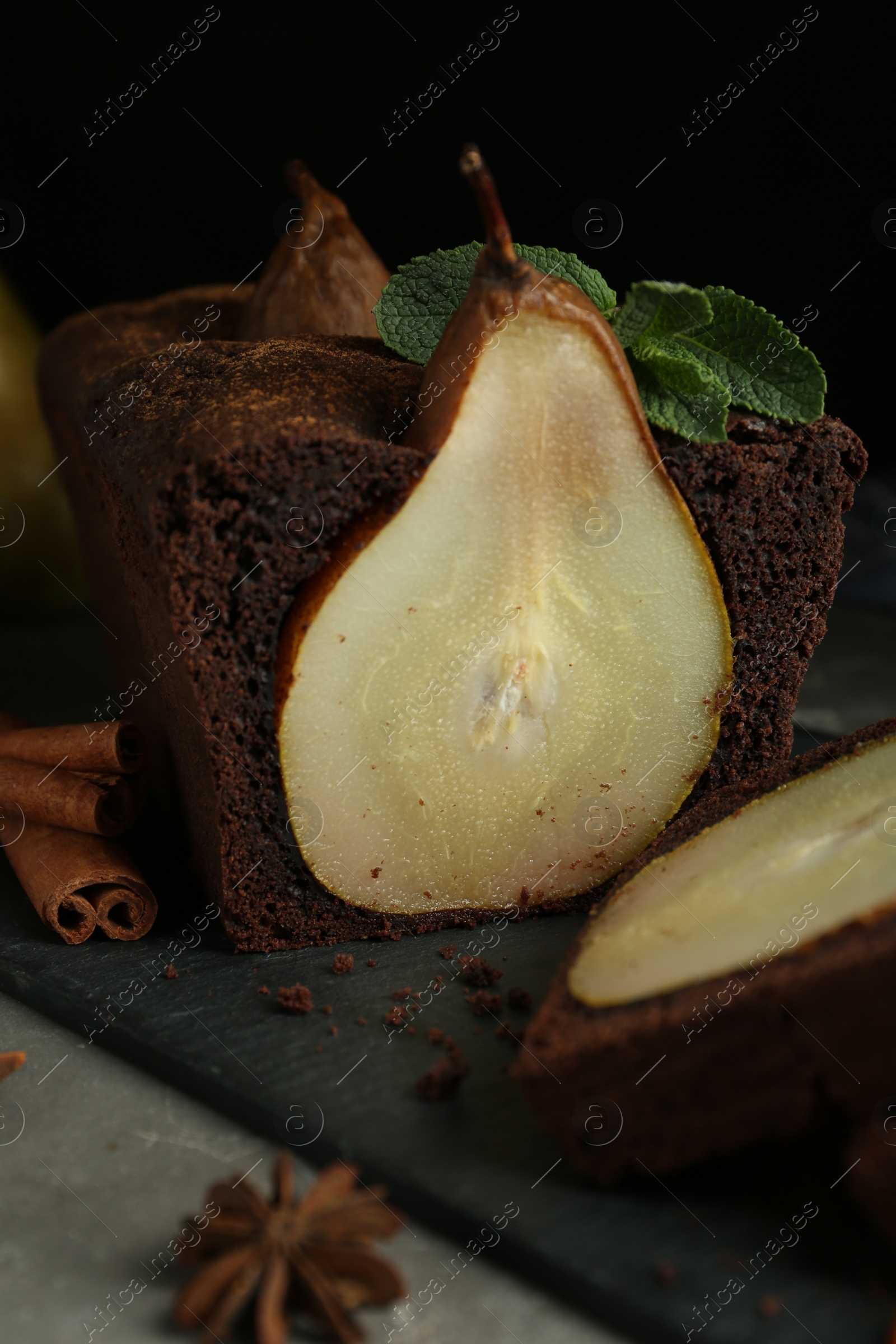 Photo of Tasty pear bread with spices and mint on grey table. Homemade cake