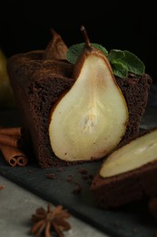 Photo of Tasty pear bread with spices and mint on grey table. Homemade cake