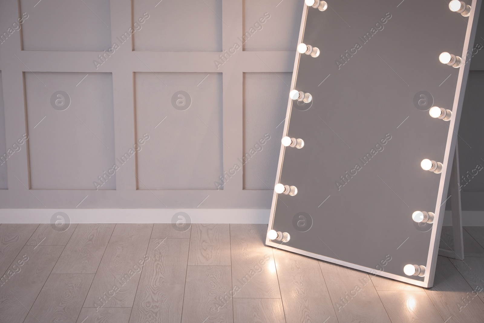 Photo of Modern mirror with light bulbs near molding wall in room, space for text