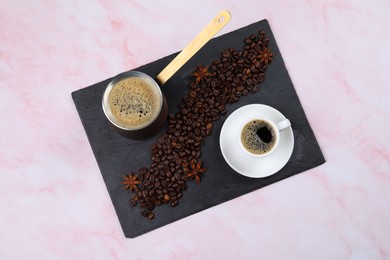 Photo of Hot turkish coffee pot, beans and anise on pink marble table, top view