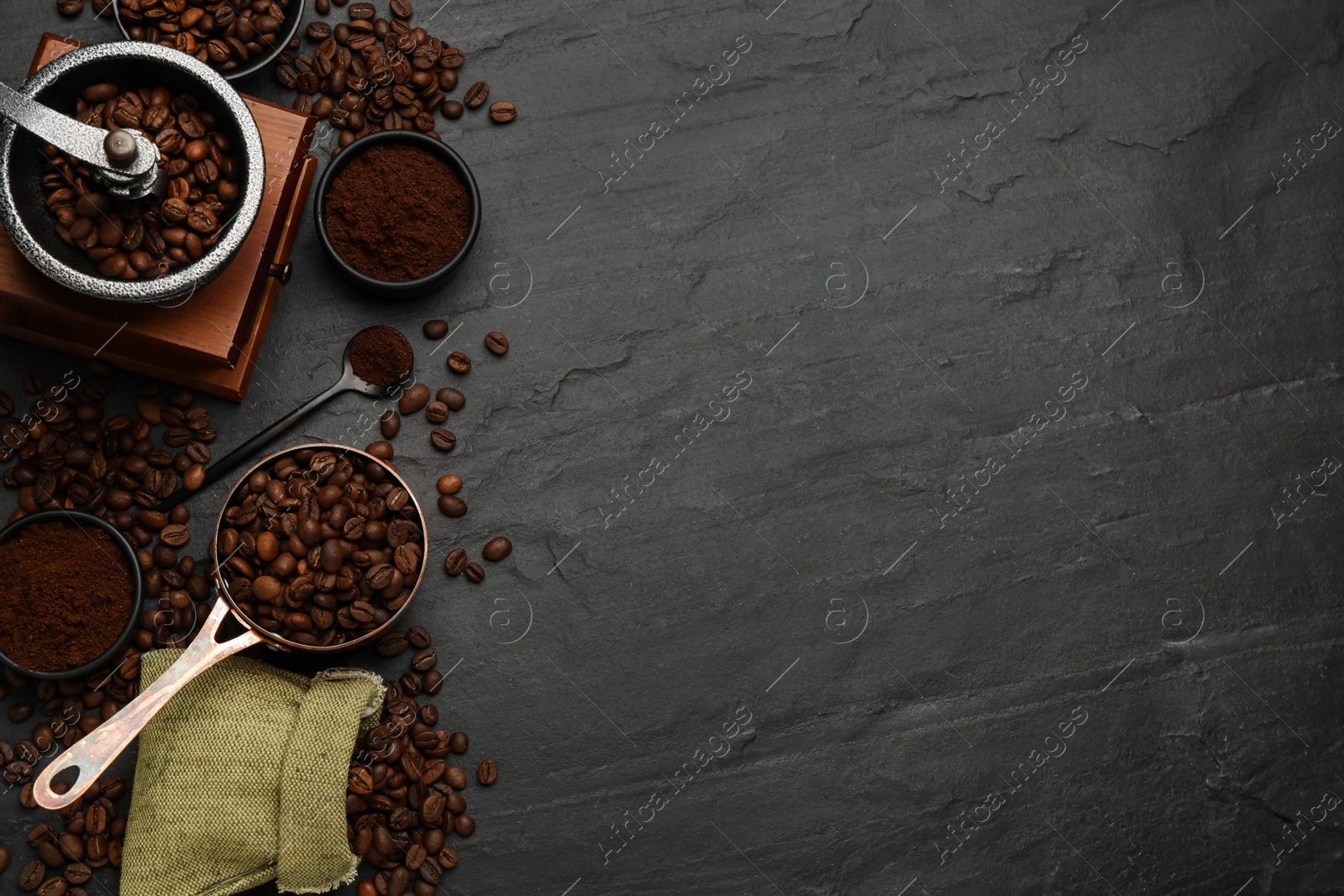 Photo of Flat lay composition with coffee grounds and roasted beans on black background, space for text