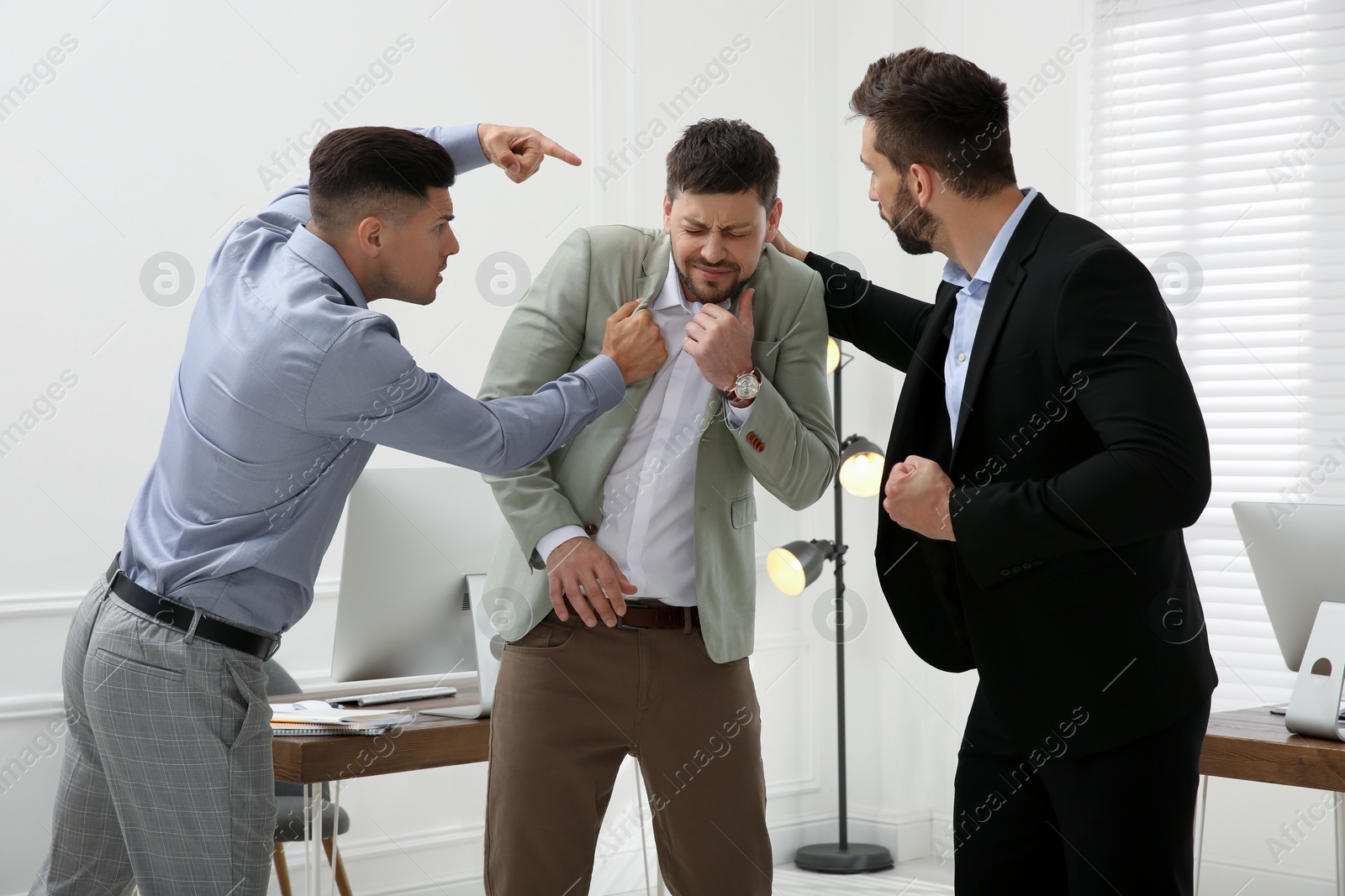 Photo of Emotional colleagues fighting in office. Workplace conflict