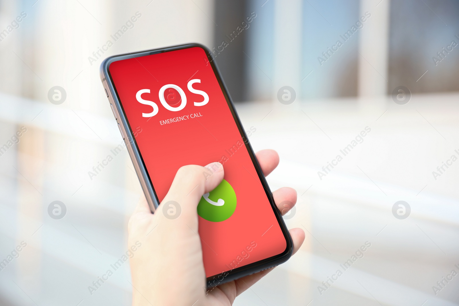 Image of Woman holding smartphone with emergency call SOS on screen outdoors, closeup