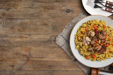 Photo of Delicious pilaf on wooden table, flat lay. Space for text