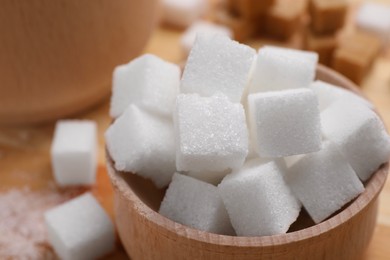 Photo of White sugar cubes in bowl on table, closeup