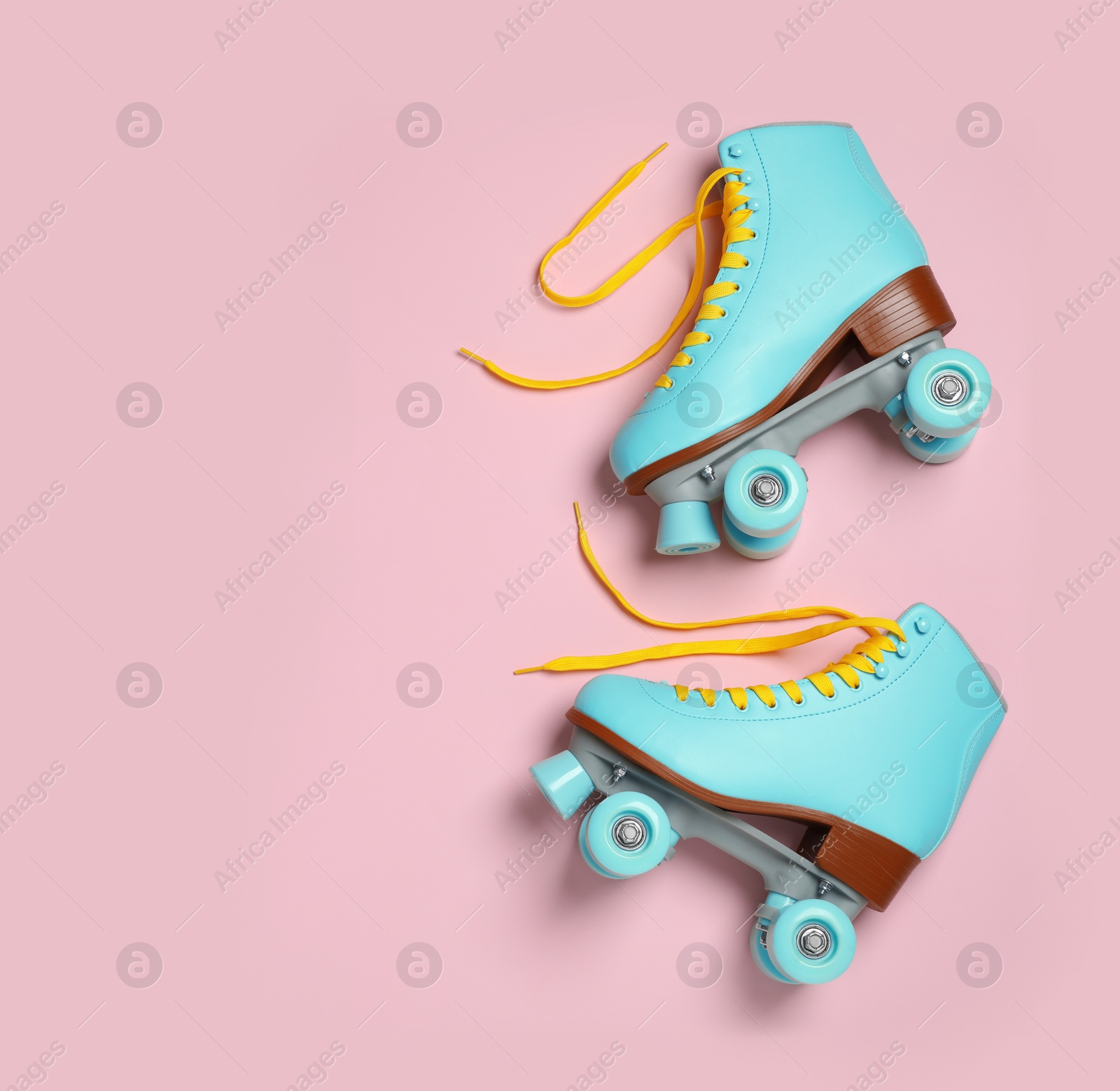 Photo of Pair of stylish quad roller skates on color background, top view with space for text