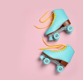 Photo of Pair of stylish quad roller skates on color background, top view with space for text