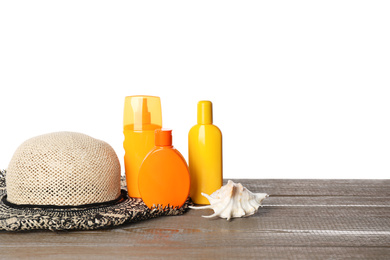 Photo of Sun protection products, hat and seashell on wooden table against white background. Space for text