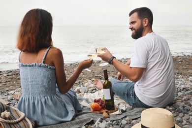 Photo of Happy young couple having picnic on beach near sea