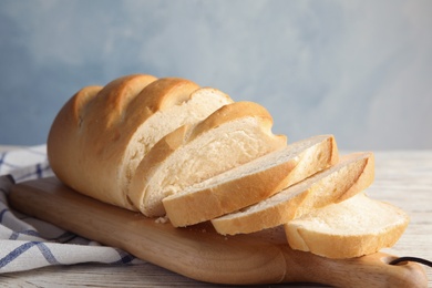 Board with tasty wheat bread on table