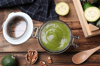 Photo of Feijoa jam in glass jar on wooden table, flat lay