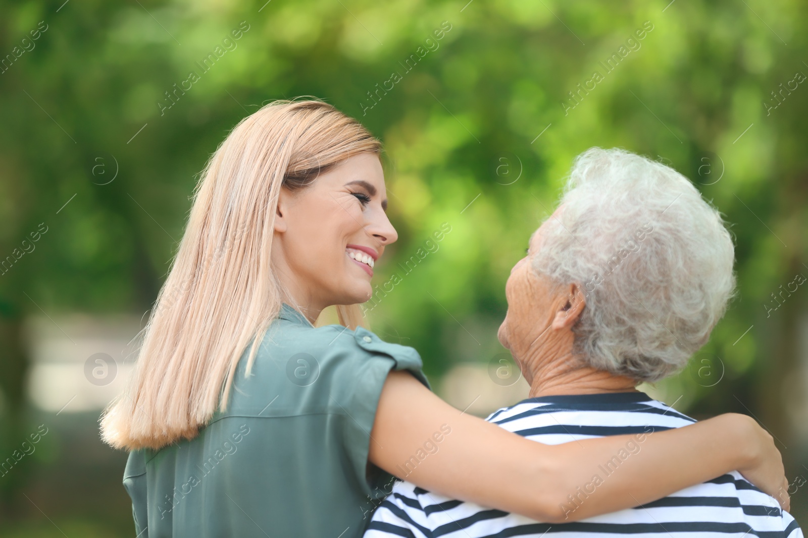 Photo of Woman with elderly mother outdoors on sunny day