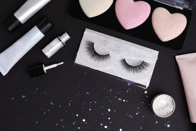 Photo of Set of makeup products on black background, flat lay