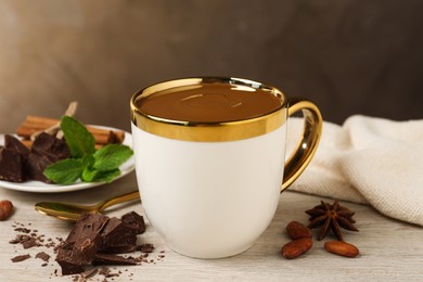 Yummy hot chocolate in cup on white wooden table