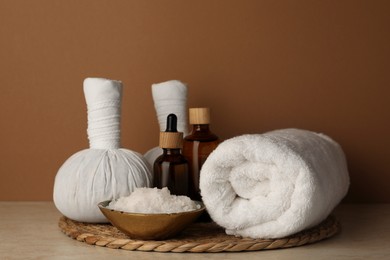 Composition with different spa products on beige table against brown background