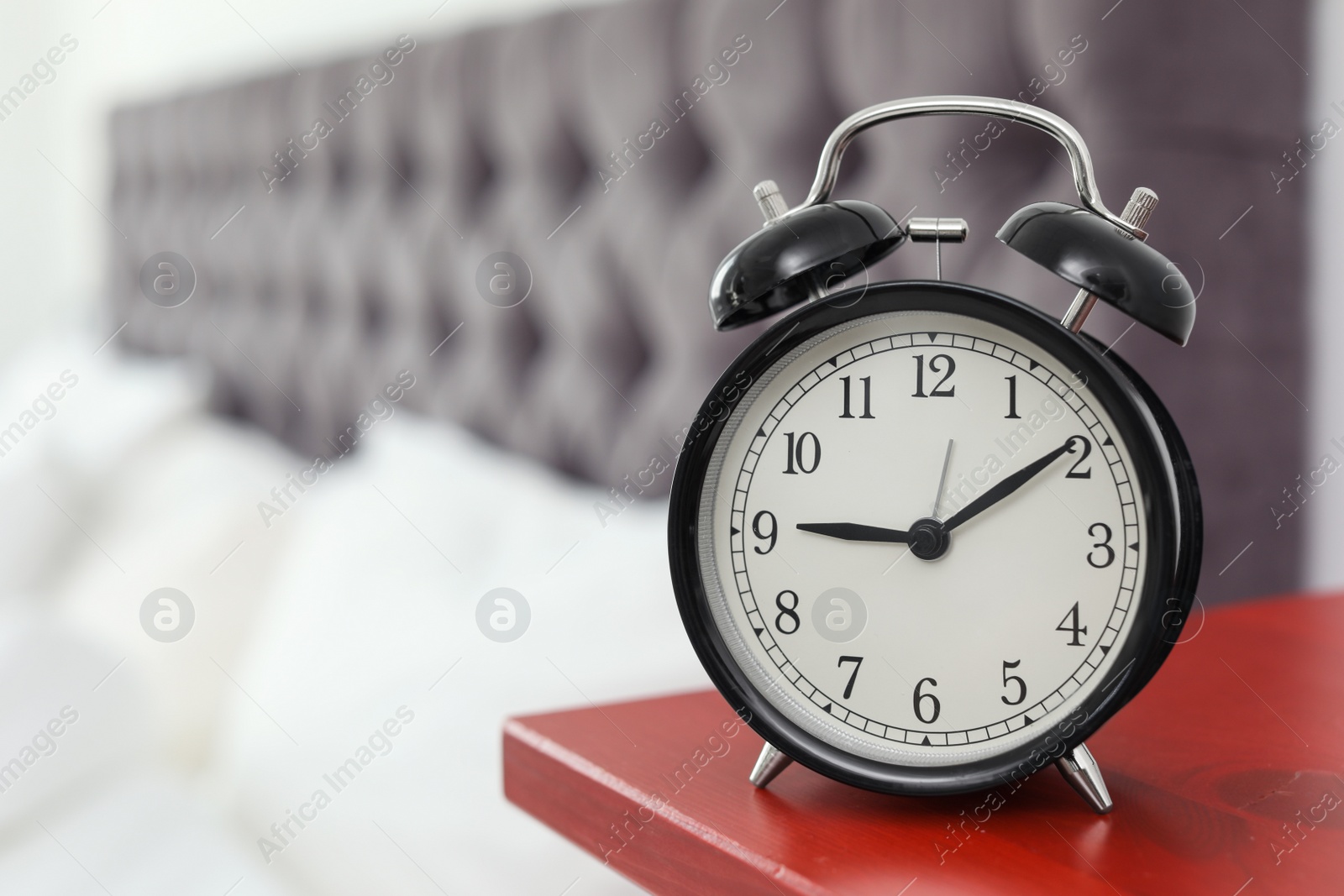 Photo of Alarm clock on bedside table. Time to wake up