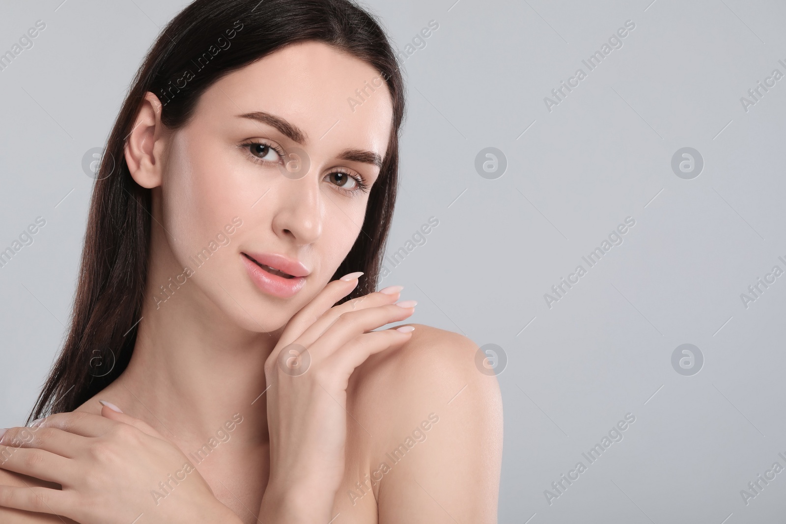 Photo of Portrait of beautiful young woman on light grey background. Space for text