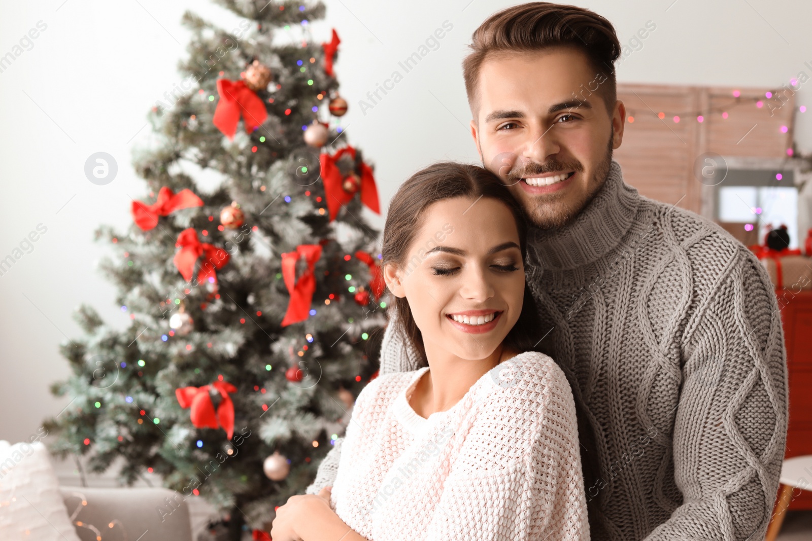 Photo of Happy young couple celebrating Christmas at home